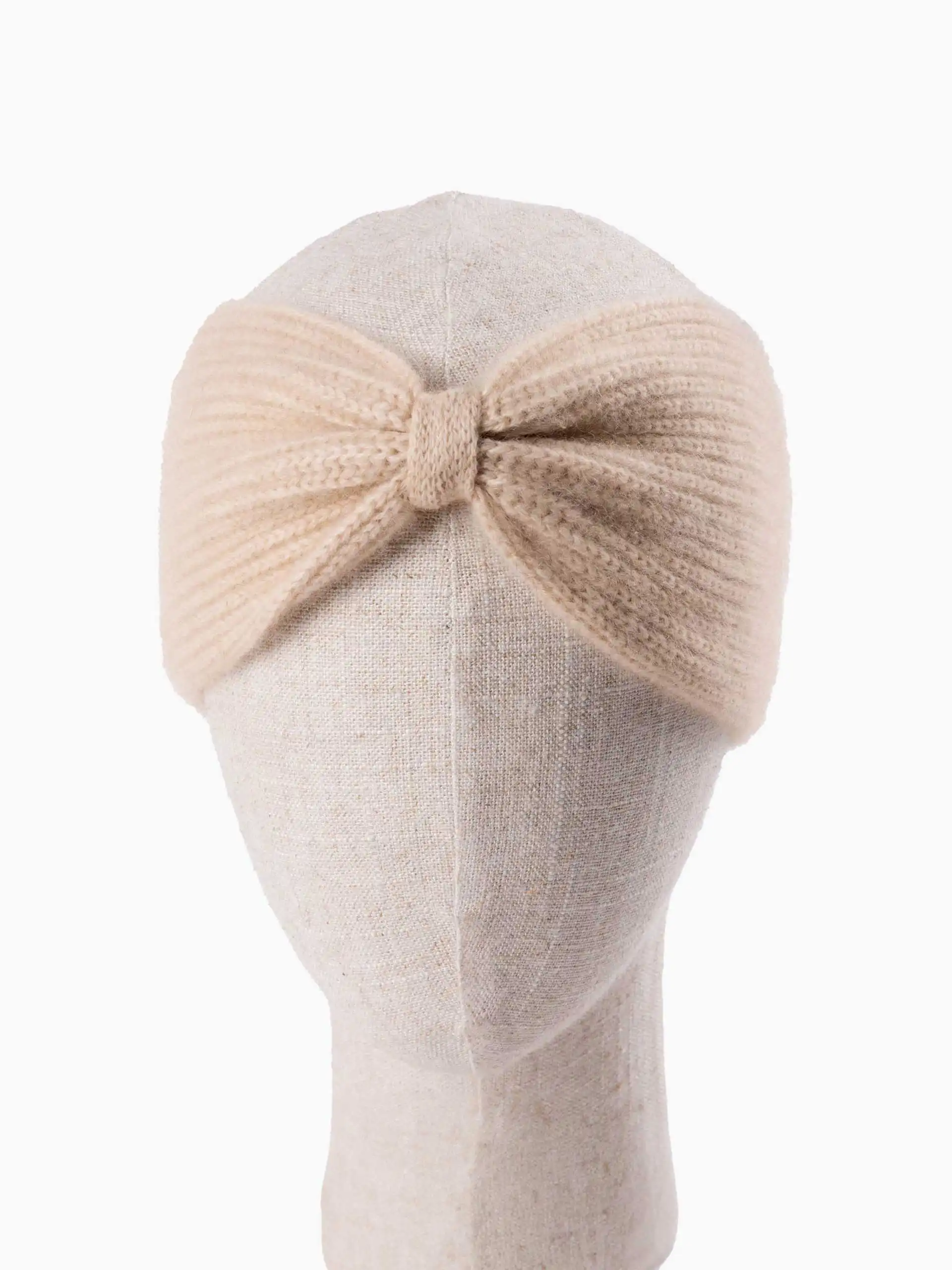 Bandeau cachemire beige avec motif torsadé vu de face sur une tête de mannequin.
