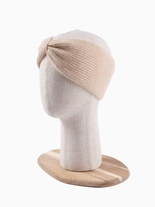 Bandeau cachemire beige tricoté, idéal pour l'hiver, vu de côté sur une tête de mannequin.