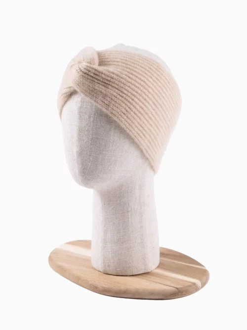 Bandeau cachemire torsade en tricot beige présenté sur un mannequin en tissu
