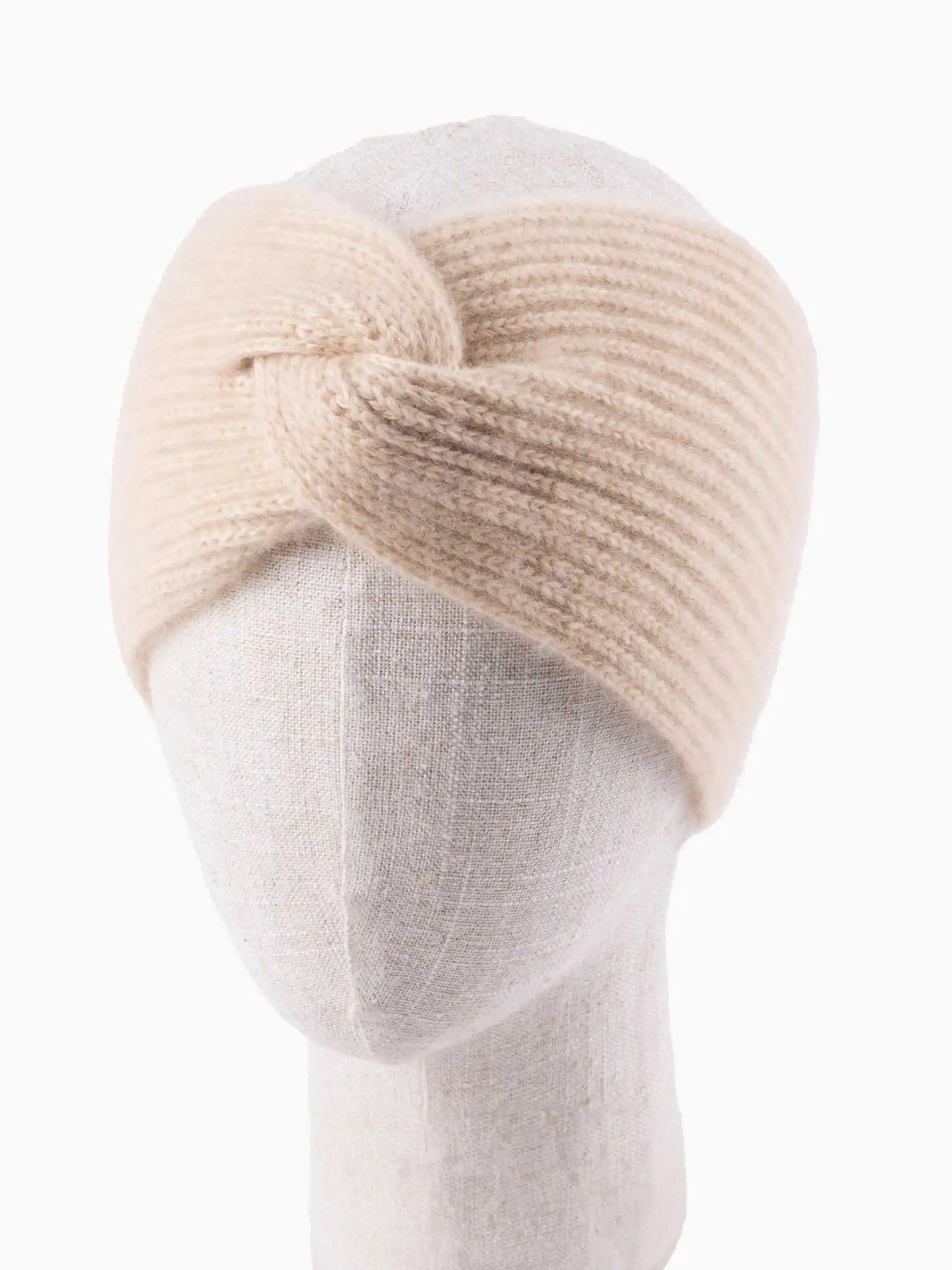 Gros plan sur un bandeau cachemire torsade beige ajusté sur un mannequin en tissu