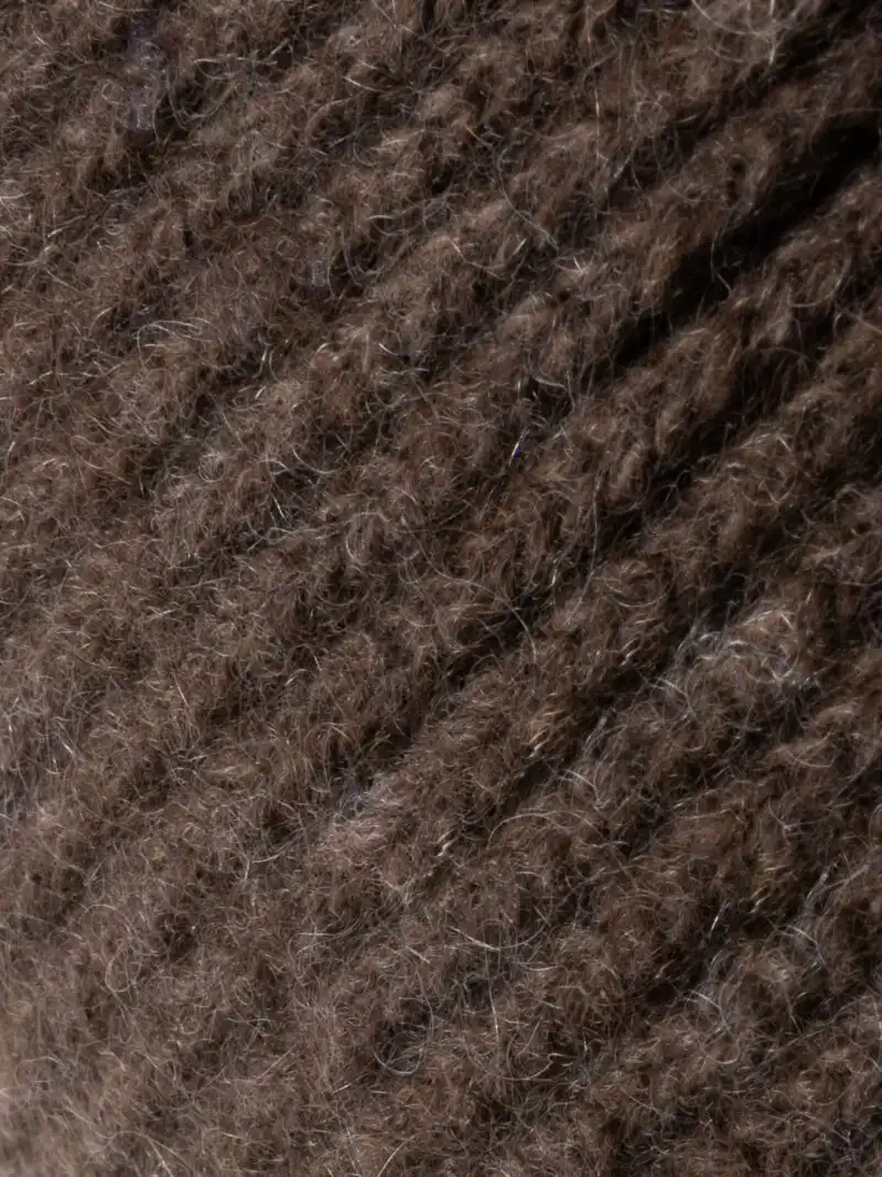 Gros plan sur un bandeau marron chocolat en laine tricotée, mettant en valeur la texture du tissu.