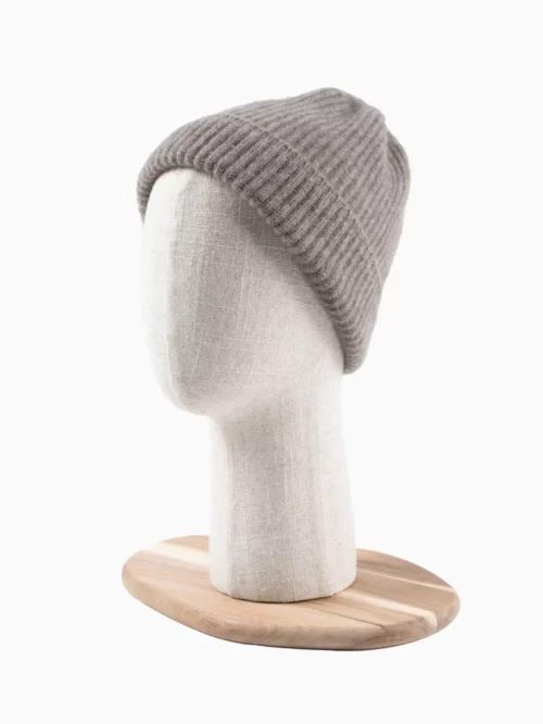 BONNET YACK Gris cendré sur un mannequin de tête en tissu beige avec socle en bois.