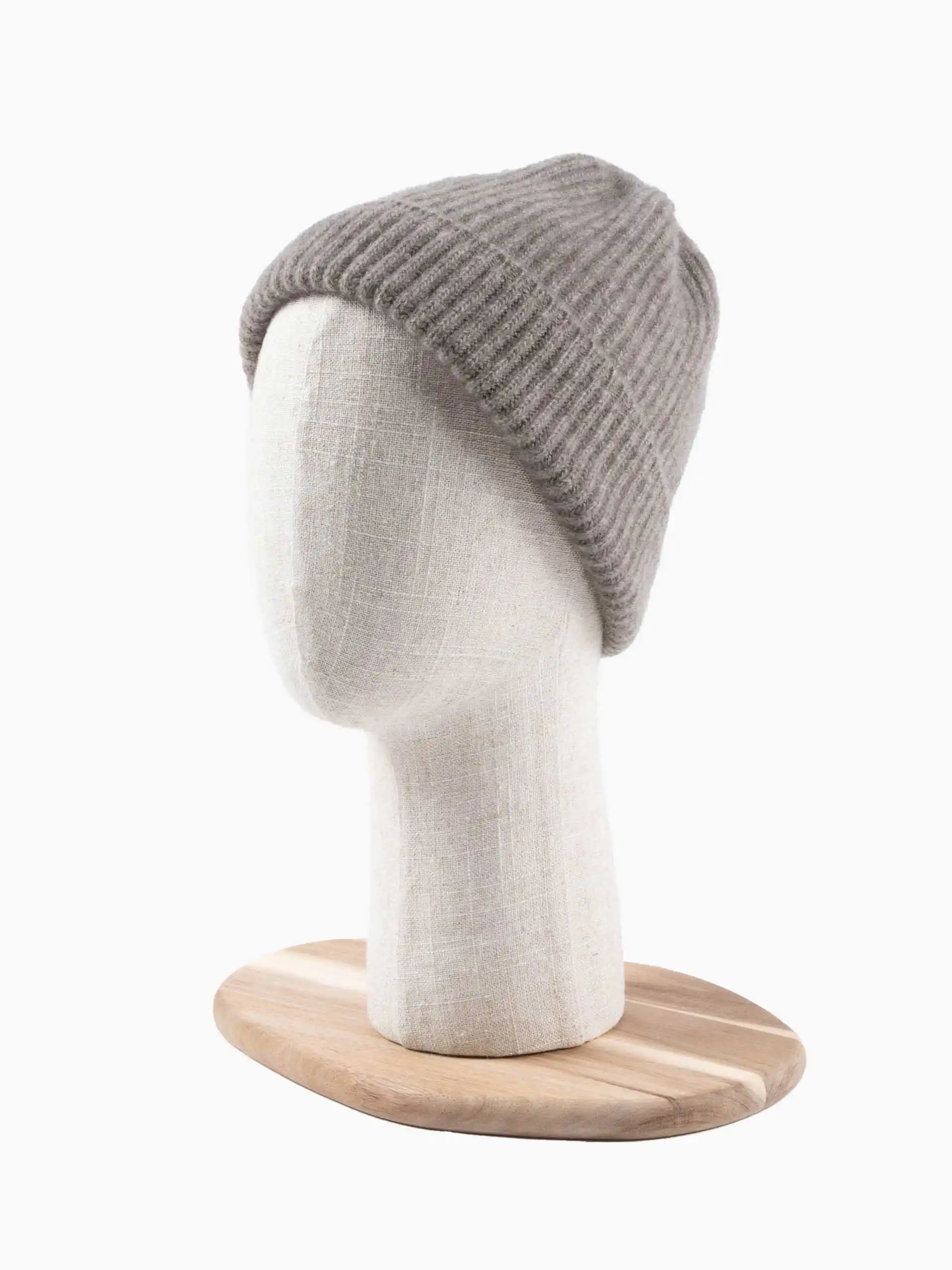BONNET YACK Gris cendré sur un mannequin de tête en tissu beige avec socle en bois.