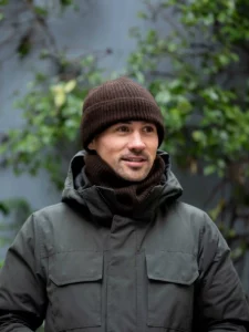Homme en veste d'hiver grise portant un BONNET YACK Marron foncé dans un cadre naturel