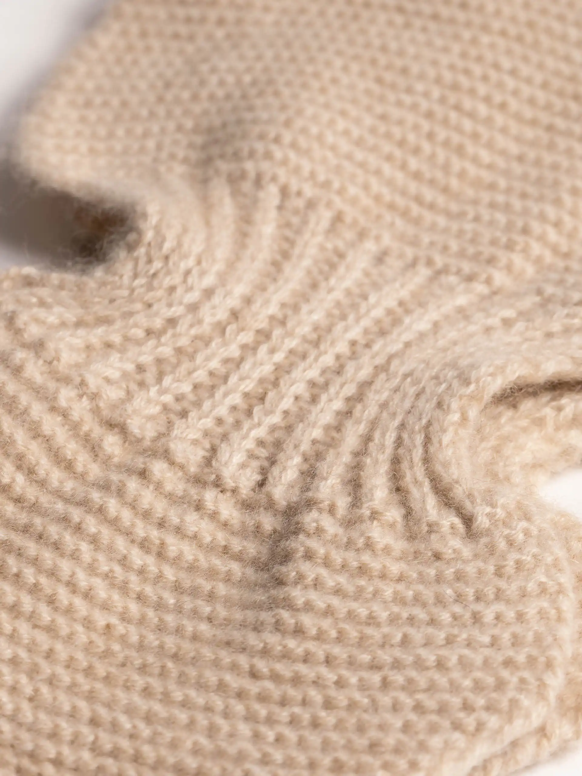 Gros plan sur le tissu doux de l'écharpe cachemire papillon beige