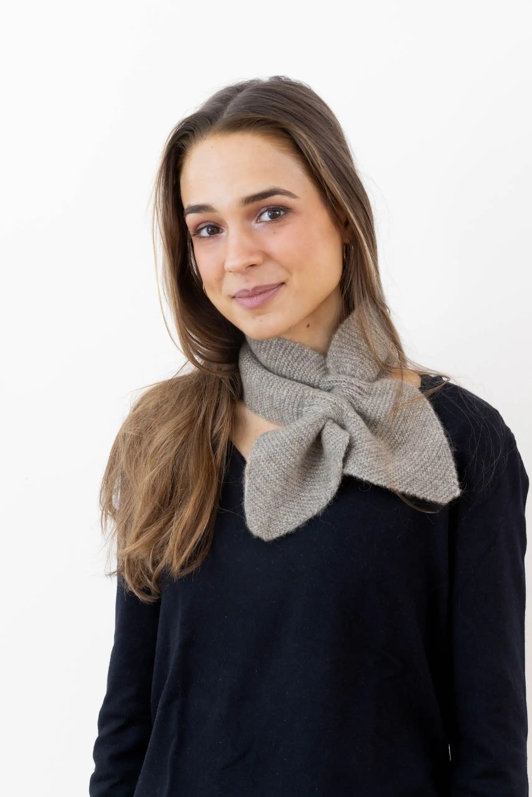 Femme portant une écharpe cachemire papillon Beige, parfaite pour les journées froides.
