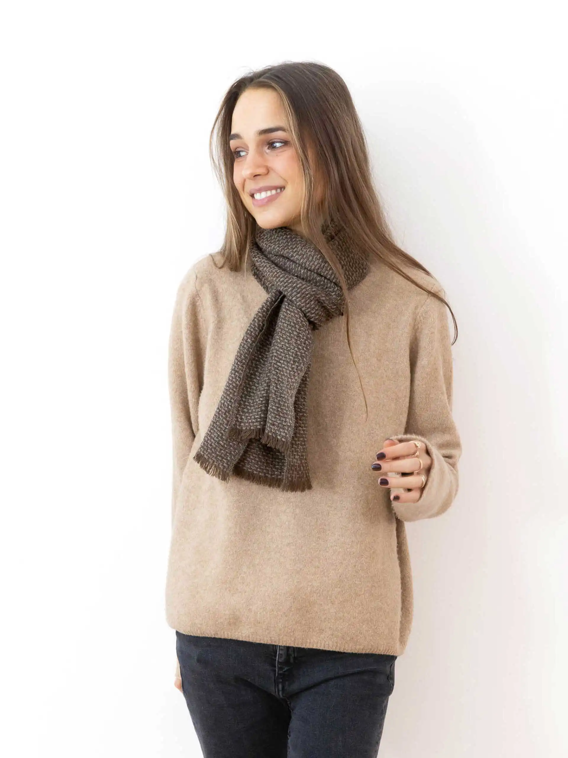 Modèle souriant portant une écharpe yack tissée, parfaite pour les tenues hivernales.