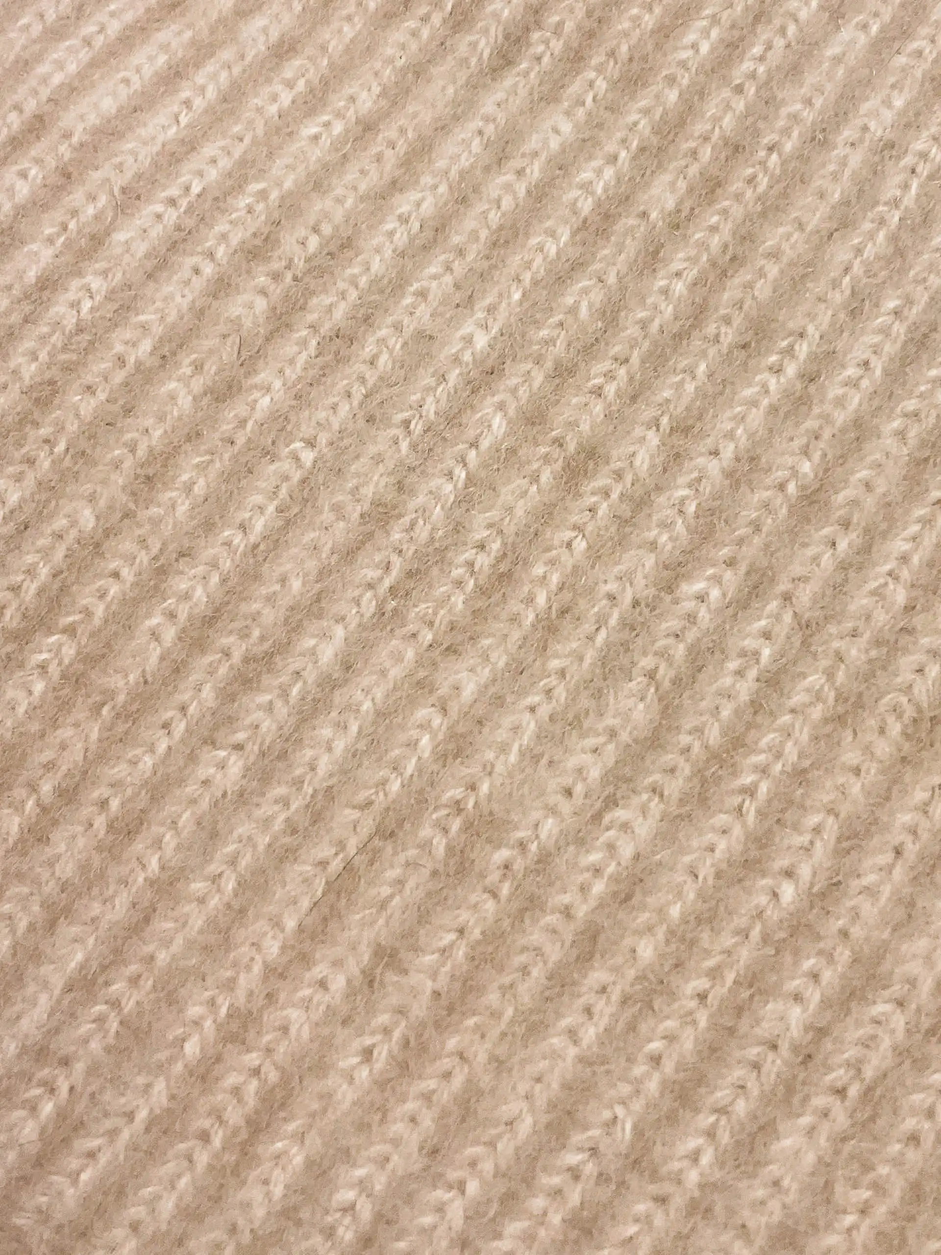 Gros plan sur la texture du tricot du tour de cou en cachemire beige, montrant les détails du tricot en laine de Mongolie.