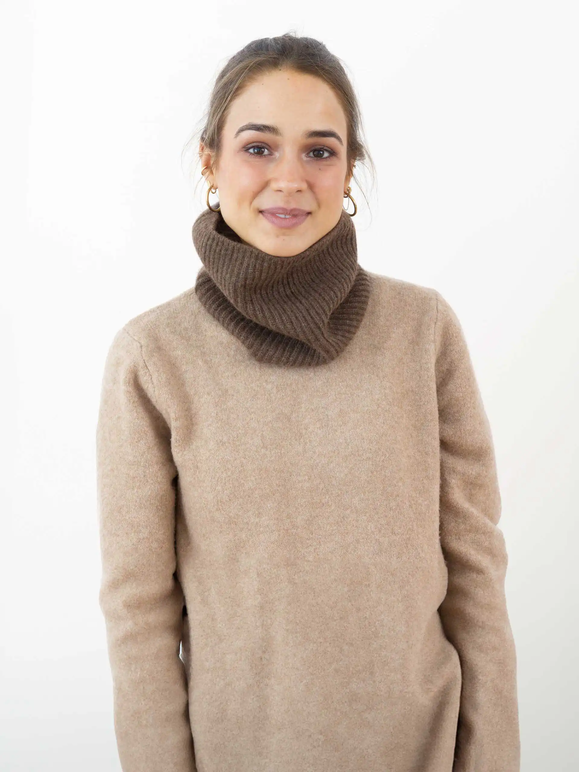 Une femme porte un tour de cou en yack marron chocolat, confectionné en laine 100% mongole. Idéal pour se protéger du froid tout en restant élégant. Disponible chez Mes Chaussettes Mongoles.