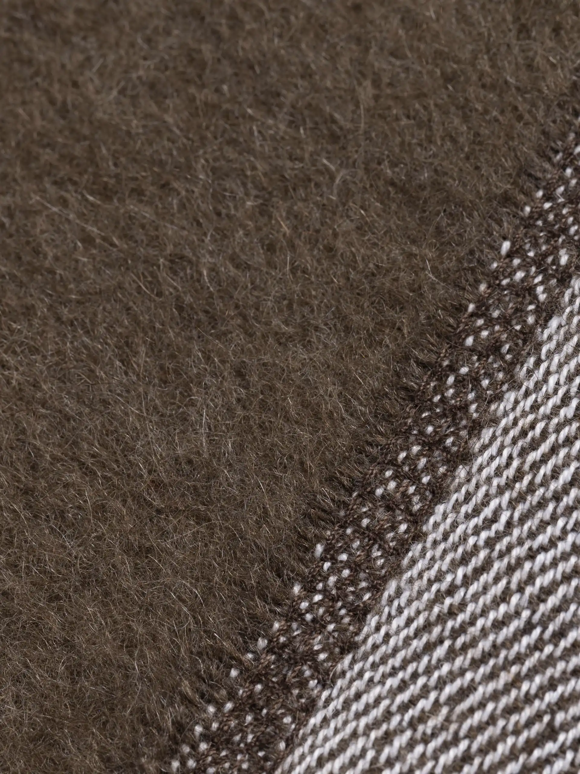 Détail du tricot du plaid marron chocolat en laine, mettant en avant sa qualité et sa douceur