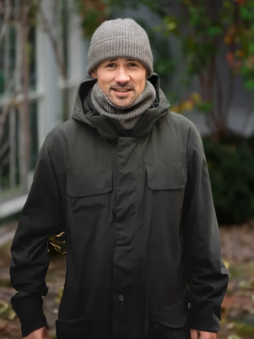 Homme posant avec un tour de cou yack gris, en tricot, devant un fond extérieur. Ce chauffe-cou élégant et chaud est idéal pour l'hiver, fabriqué en laine de yack 100 % mongol.