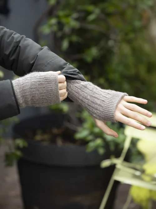 Personne en train de porter des mitaines yack gris cendré, idéal pour l'hiver