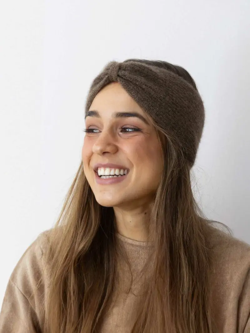 Ce bandeau marron chocolat en laine est l'accessoire parfait pour compléter votre tenue d'hiver. Porté par un modèle féminin, il met en valeur les cheveux et la couleur tout en offrant une protection efficace contre le froid. Idéal pour ajouter une touche élégante à votre garde-robe hivernale.