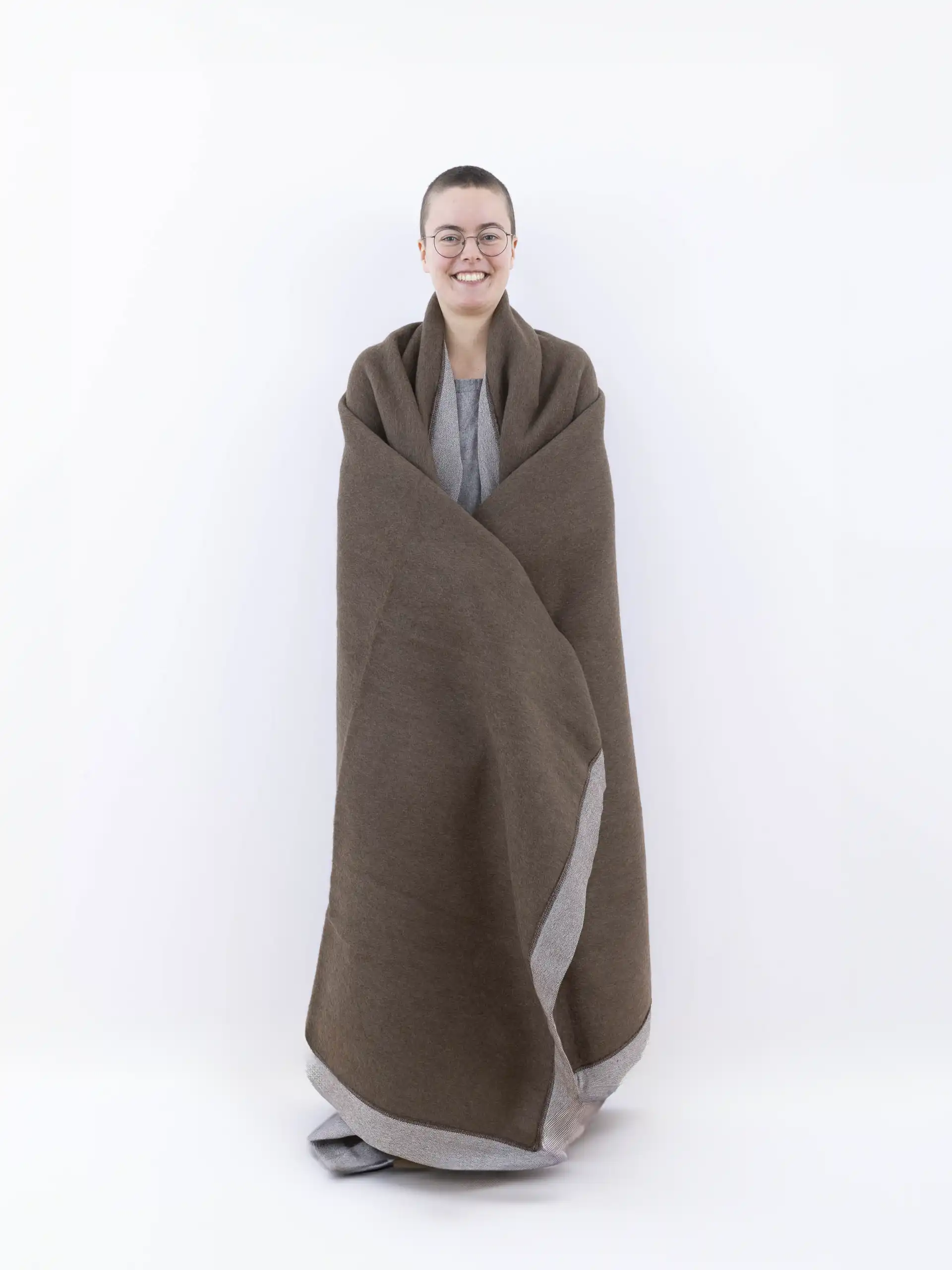 Modèle enveloppé dans un plaid marron chocolat en laine, montrant sa grande taille et son confort