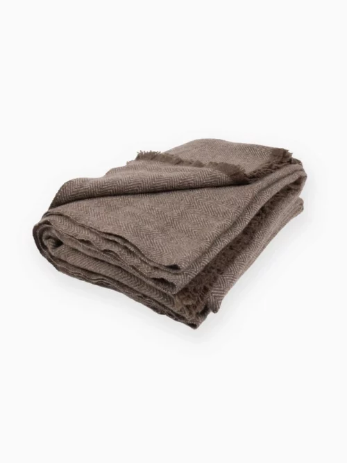 Plaid Yack Hiver tricoté, 100% mongol, plié et présenté sur une surface blanche