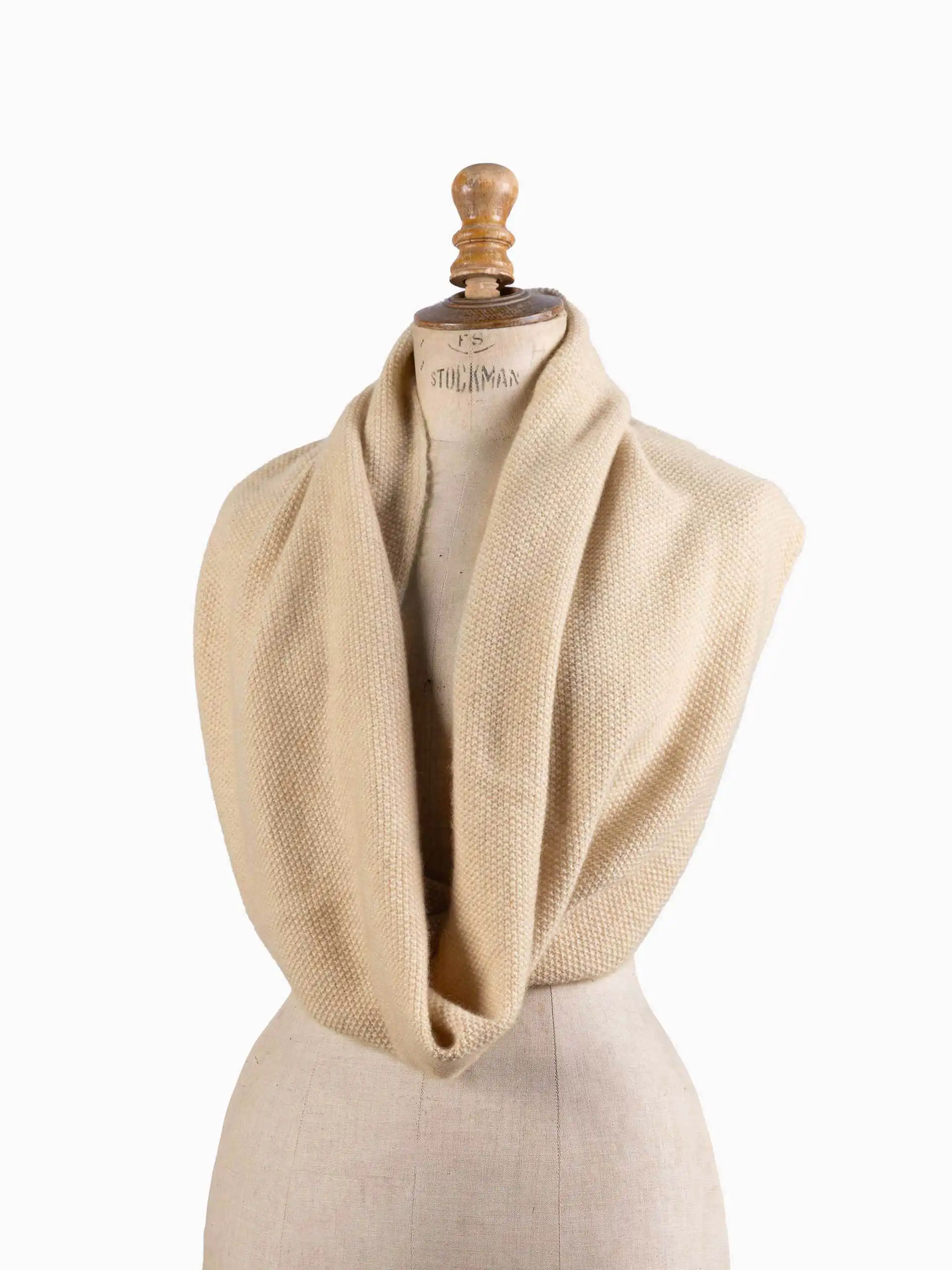 Snood cachemire beige exposé sur un mannequin, montrant son style élégant et sa qualité de fabrication.