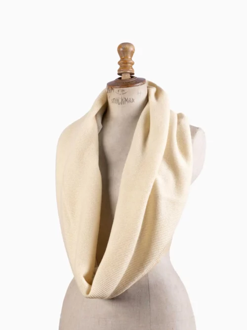 Snood cachemire blanc crème présenté sur un mannequin, illustrant son élégance et son style raffiné.