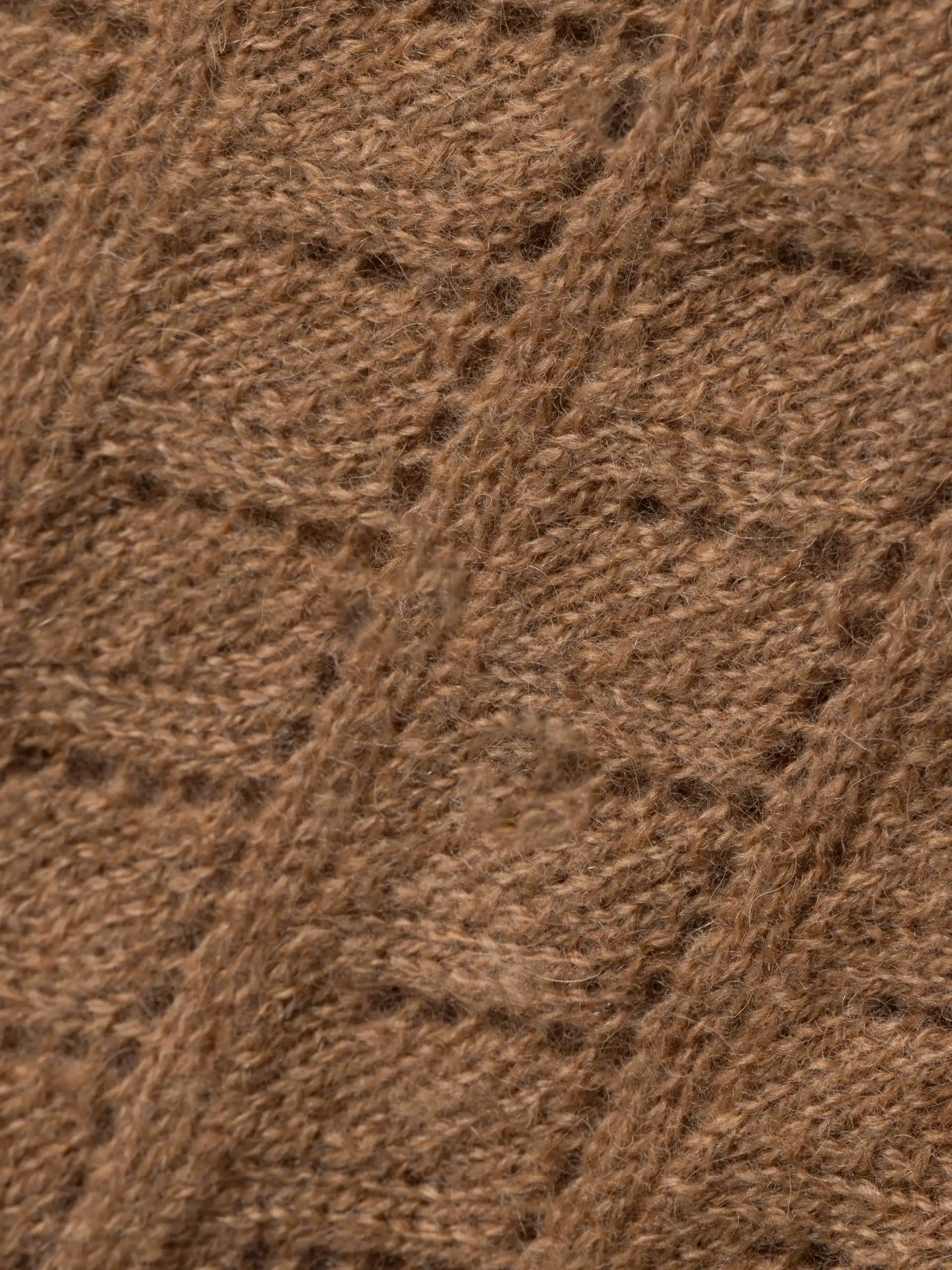 Gros plan sur la texture douce et chaude de l'écharpe chameau fine, parfait pour l'hiver.