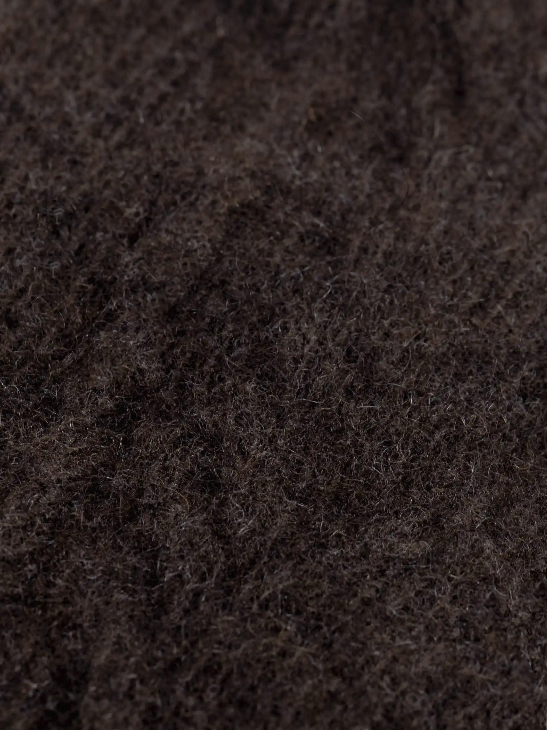 Gros plan sur la texture des moufles en yack marron foncé.