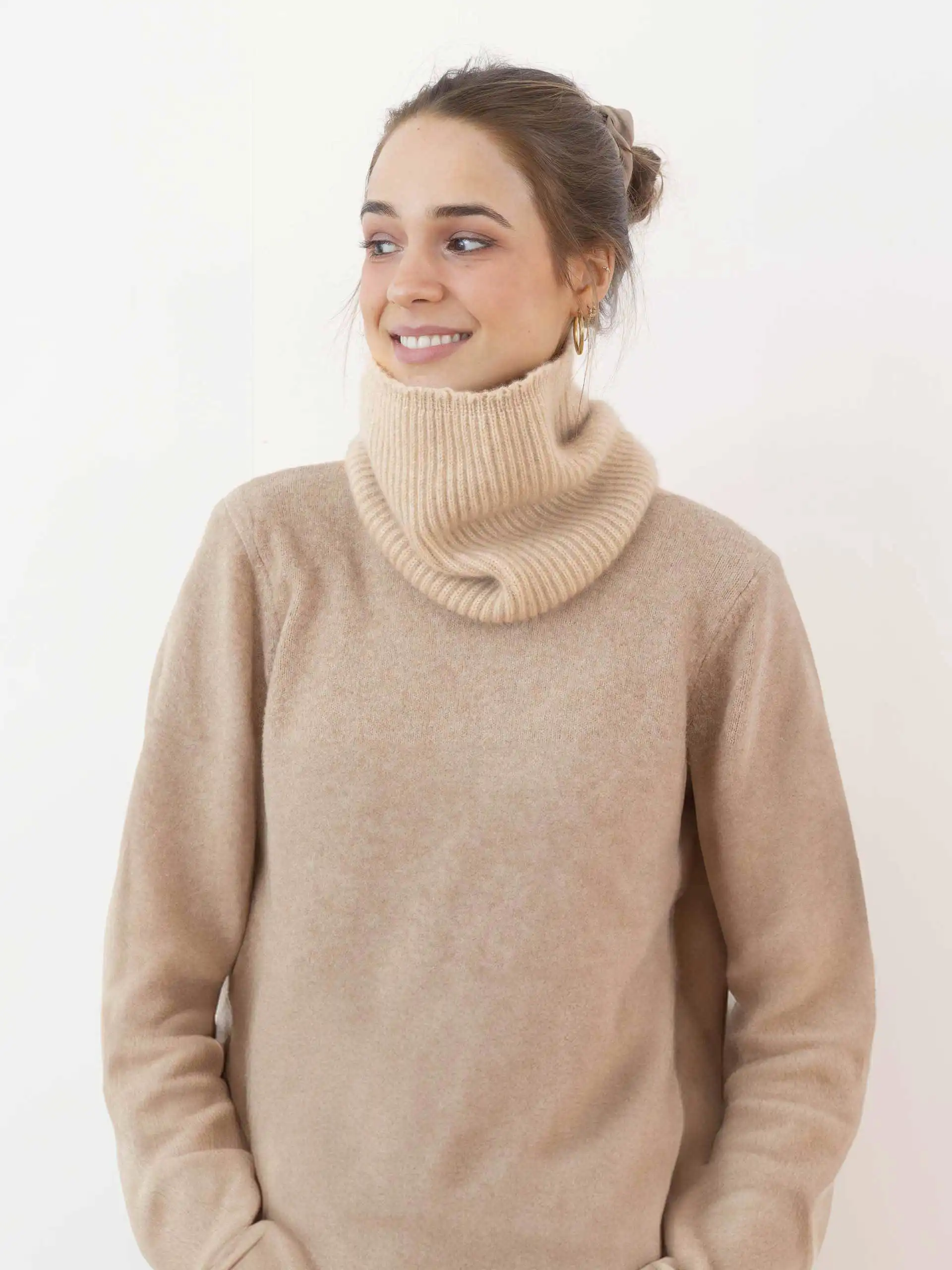 Jeune femme portant un tour de cou en cachemire beige, illustrant la douceur et la chaleur du tricot en laine mongole, idéal pour se protéger du froid.