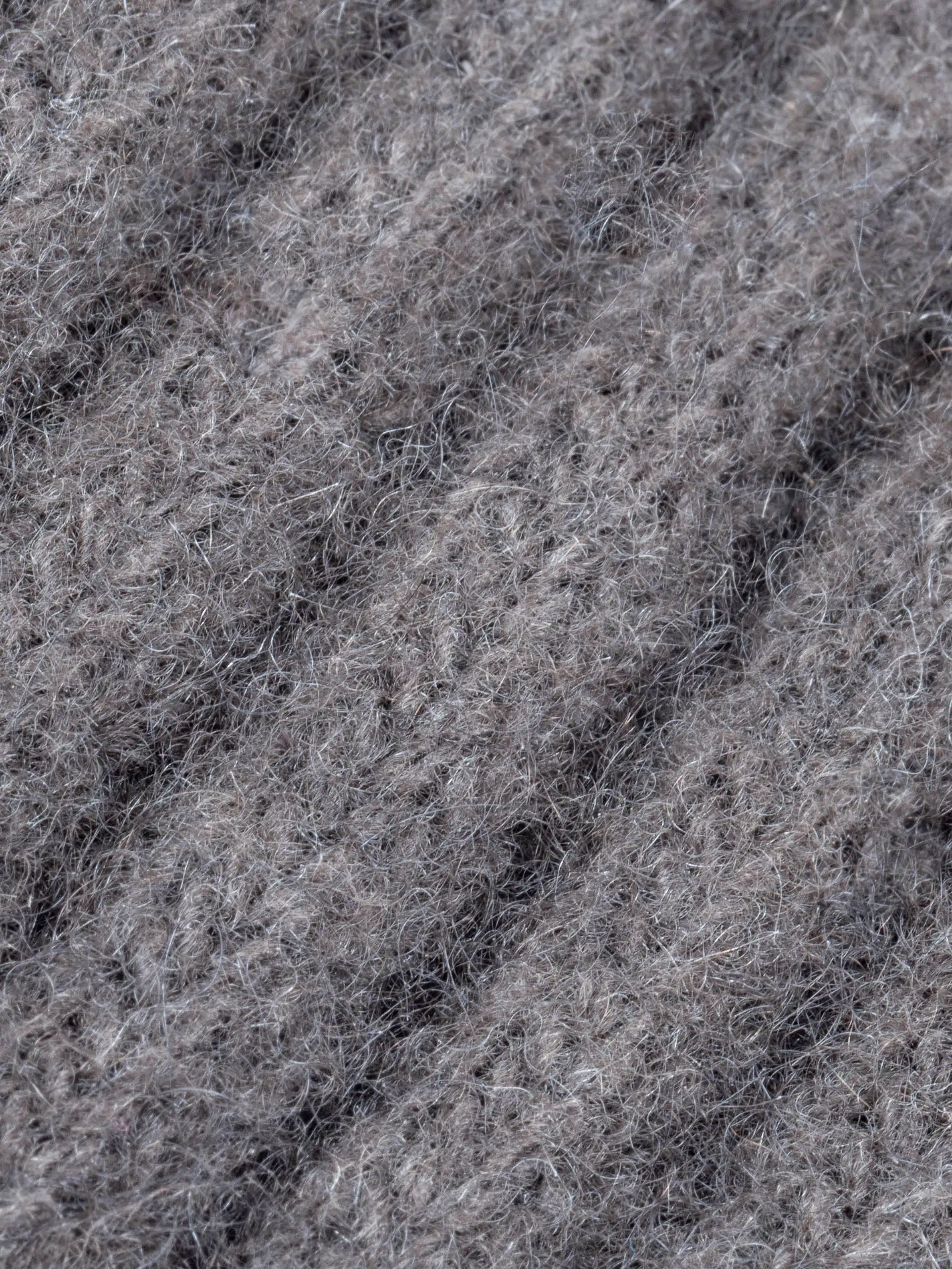 Gros plan sur la texture du tricot du tour de cou yack gris cendré, montrant les détails de la laine douce et duveteuse.