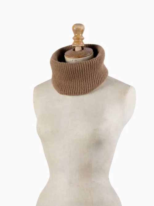 L'image présente un tour de cou camel, soigneusement tricoté et exposé sur un mannequin. Fabriqué à partir de laine de chameau 100 % mongol, ce chauffe-cou offre une chaleur exceptionnelle et un confort luxueux. Parfait pour les adultes recherchant une solution élégante et pratique pour l'hiver, ce tour de cou est disponible chez
