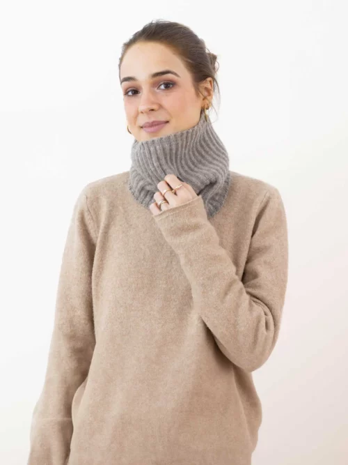 Femme portant un tour de cou yack gris cendré, tricoté, en laine de yack 100% mongol. Idéal pour se réchauffer en hiver avec élégance et confort.