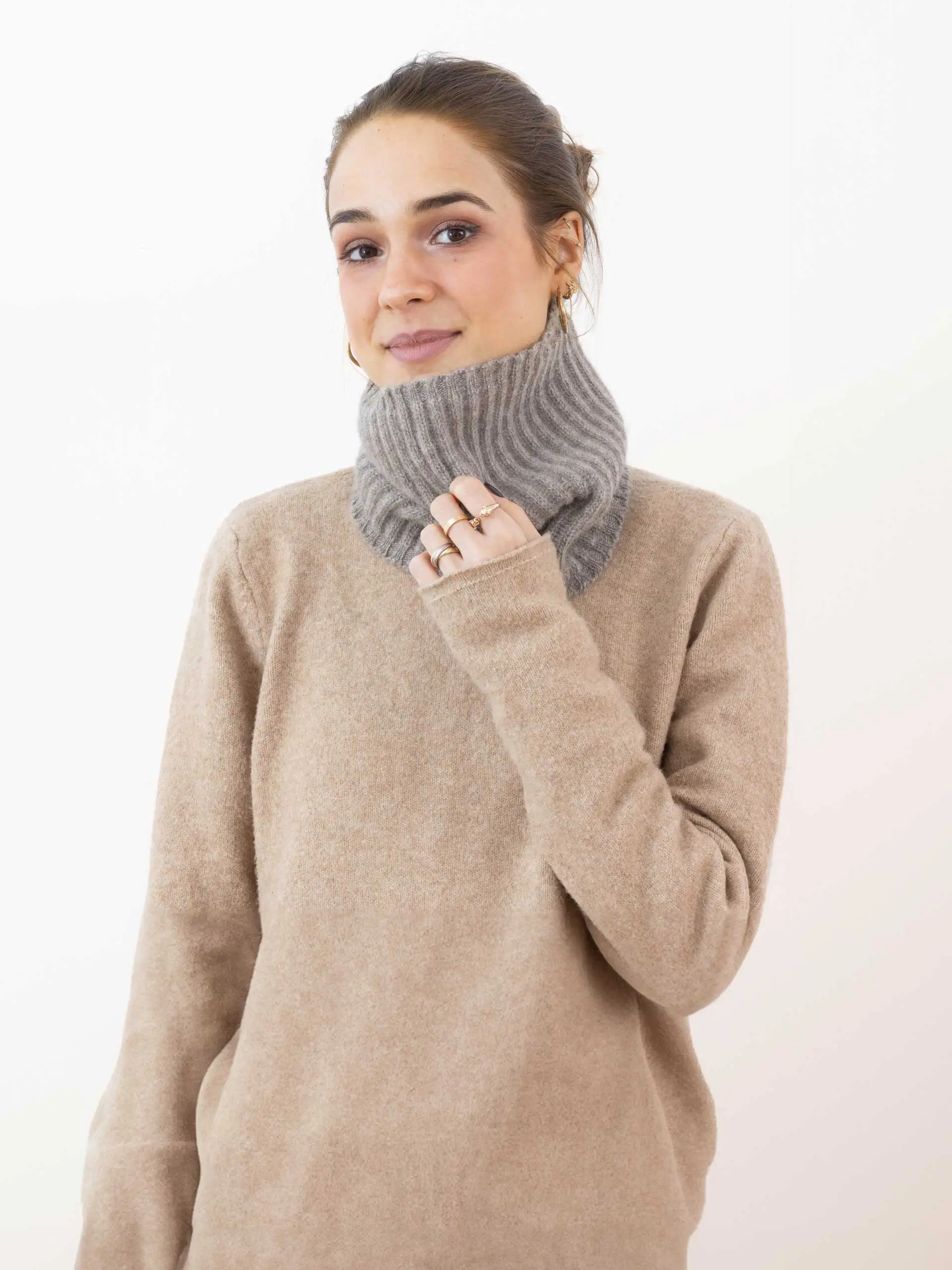 Femme portant un tour de cou yack gris cendré, tricoté, en laine de yack 100% mongol. Idéal pour se réchauffer en hiver avec élégance et confort.
