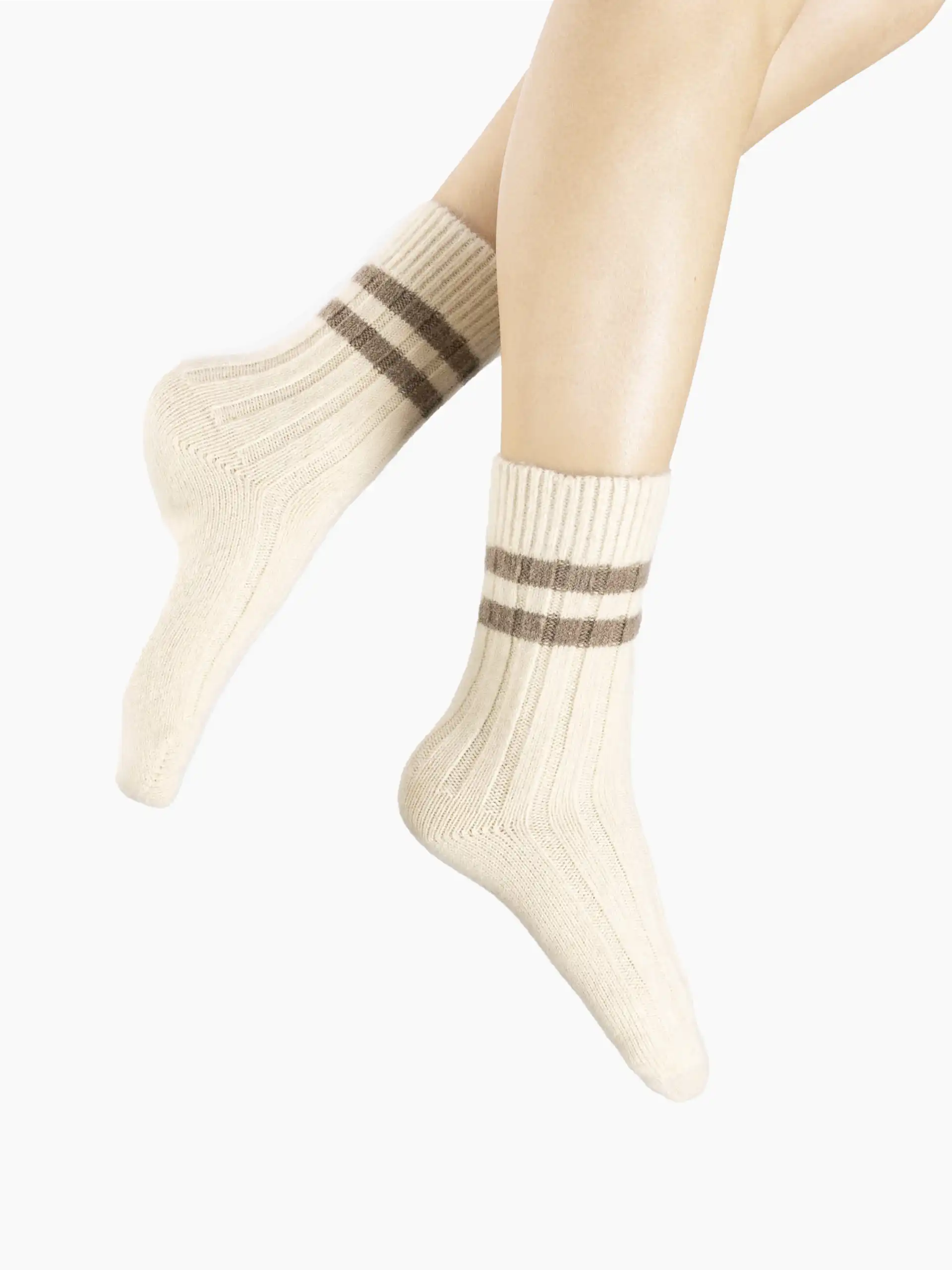 Chaussettes cachemire beige en laine portées par une femme, idéales pour l'hiver.