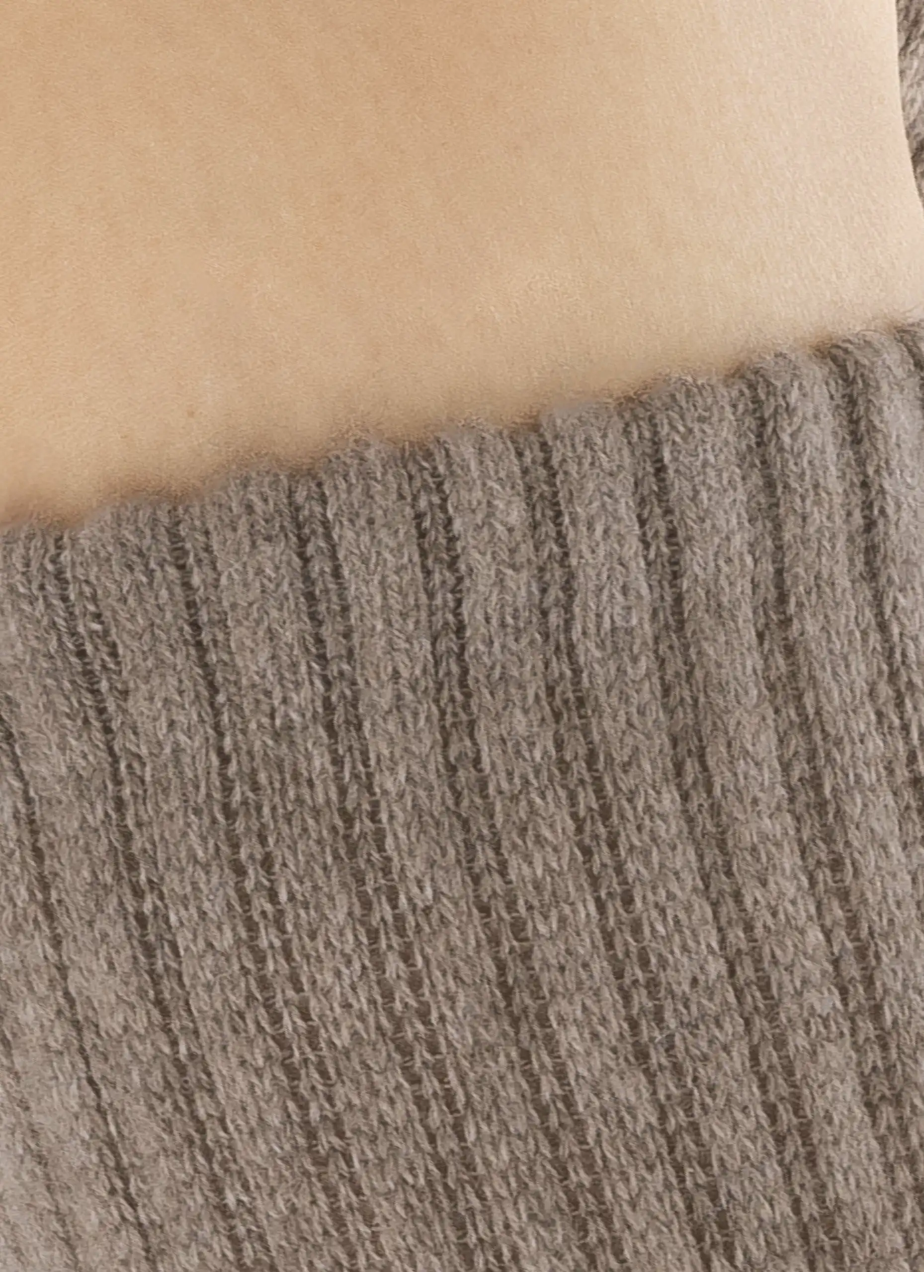 Gros plan sur des chaussettes en cachemire gris tricotées pour homme et femme, parfaites pour garder vos pieds au chaud en hiver.