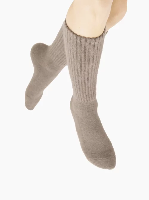 Chaussettes en cachemire gris portées, montrant leur texture douce et tricotée, parfaites pour femmes et hommes.