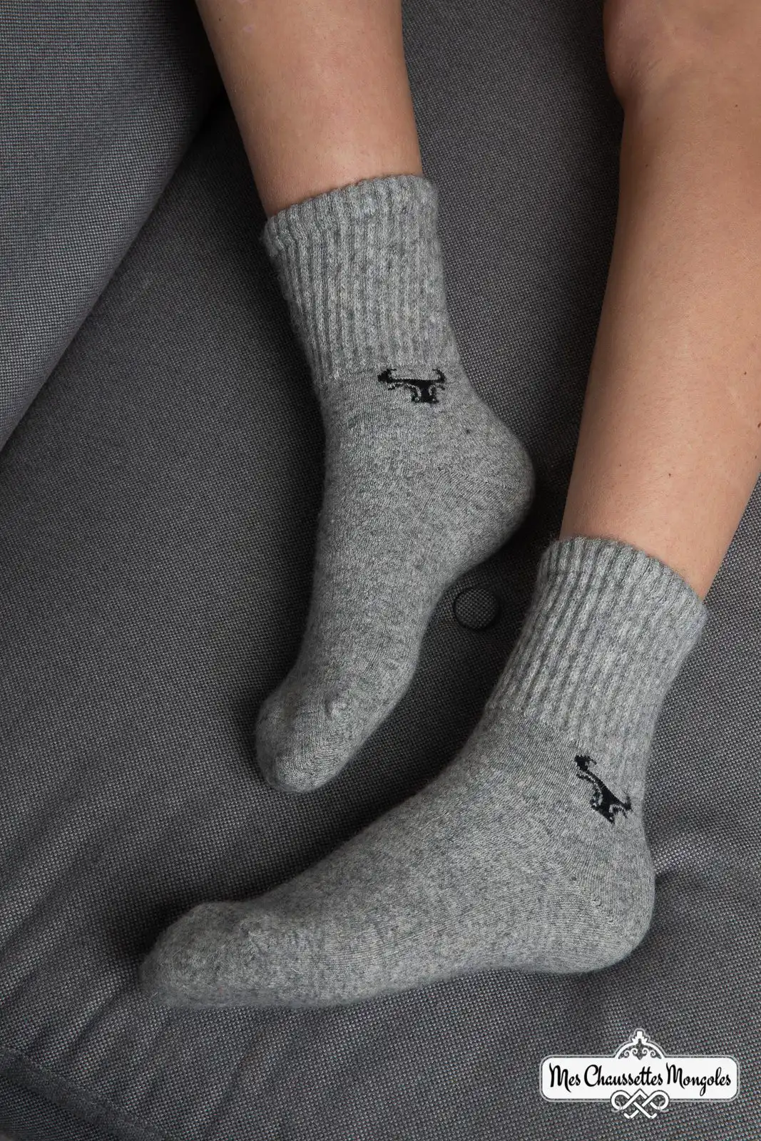 Chaussettes grises motif yack portées sur un canapé