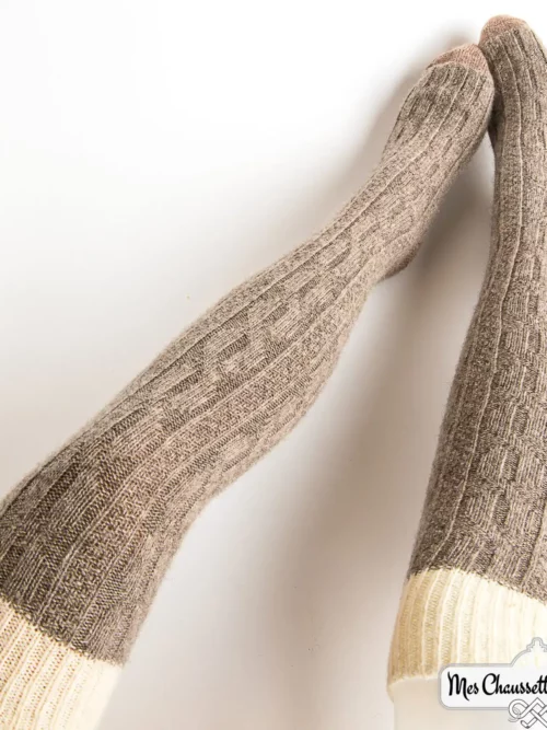 Une paire de chaussettes longues gris cendré avec une bande blanche, idéales pour les femmes par temps froid.