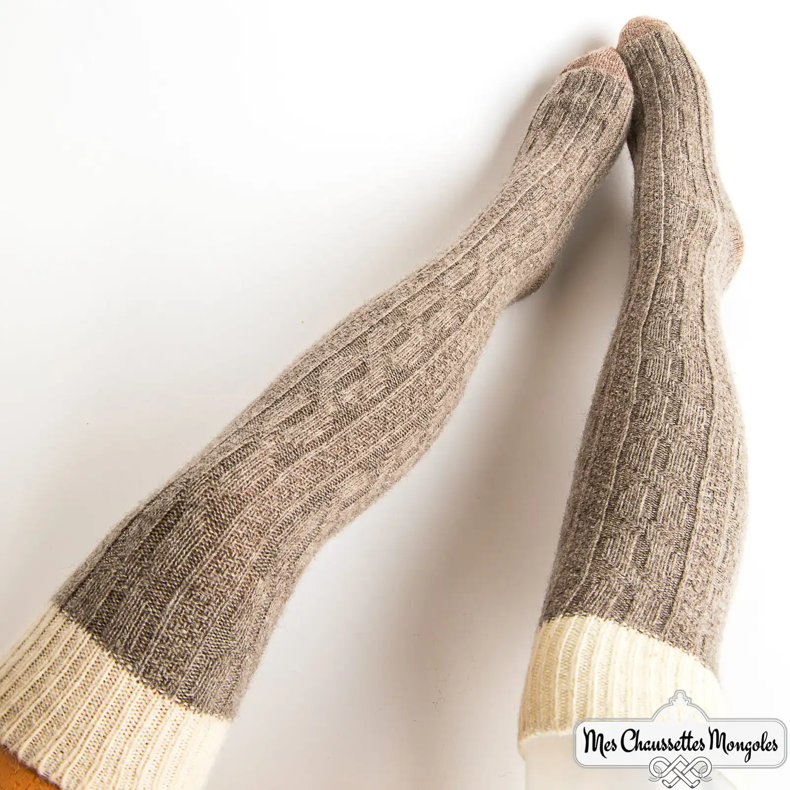 Une paire de chaussettes longues gris cendré avec une bande blanche, idéales pour les femmes par temps froid.