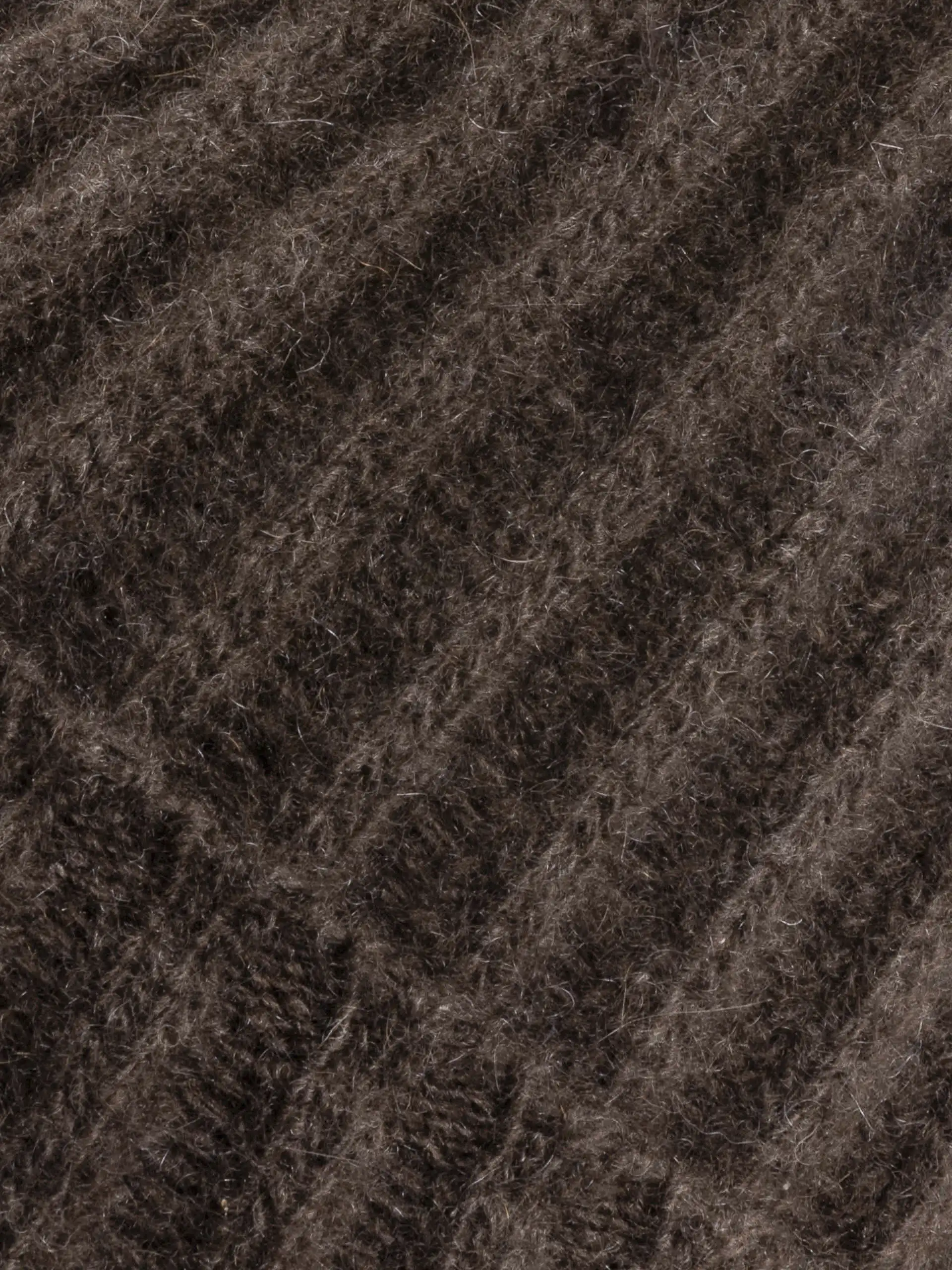 Gros plan sur la texture de la maille épaisse du bonnet enfant en duvet de Mongolie.