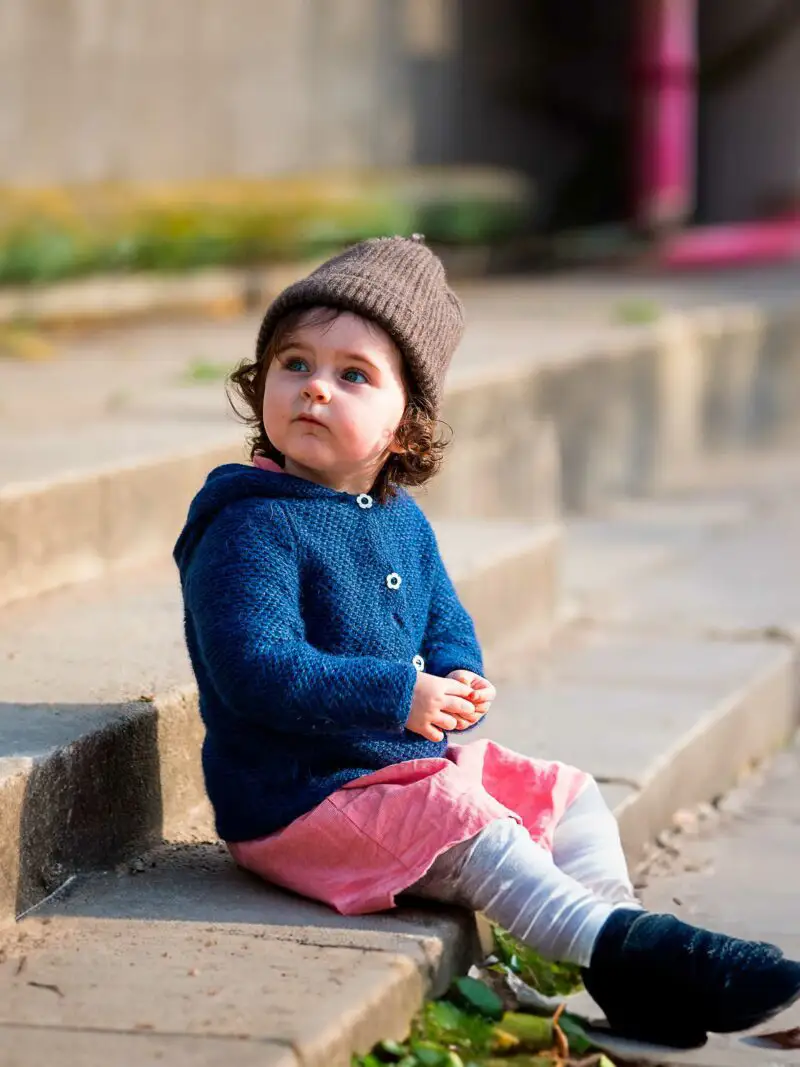 Enfant assis avec un bonnet marron chocolat en duvet de yack