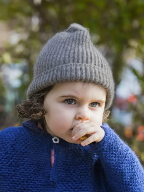 Enfant portant un bonnet enfant gris cendré en duvet yack de Mongolie, en extérieur.