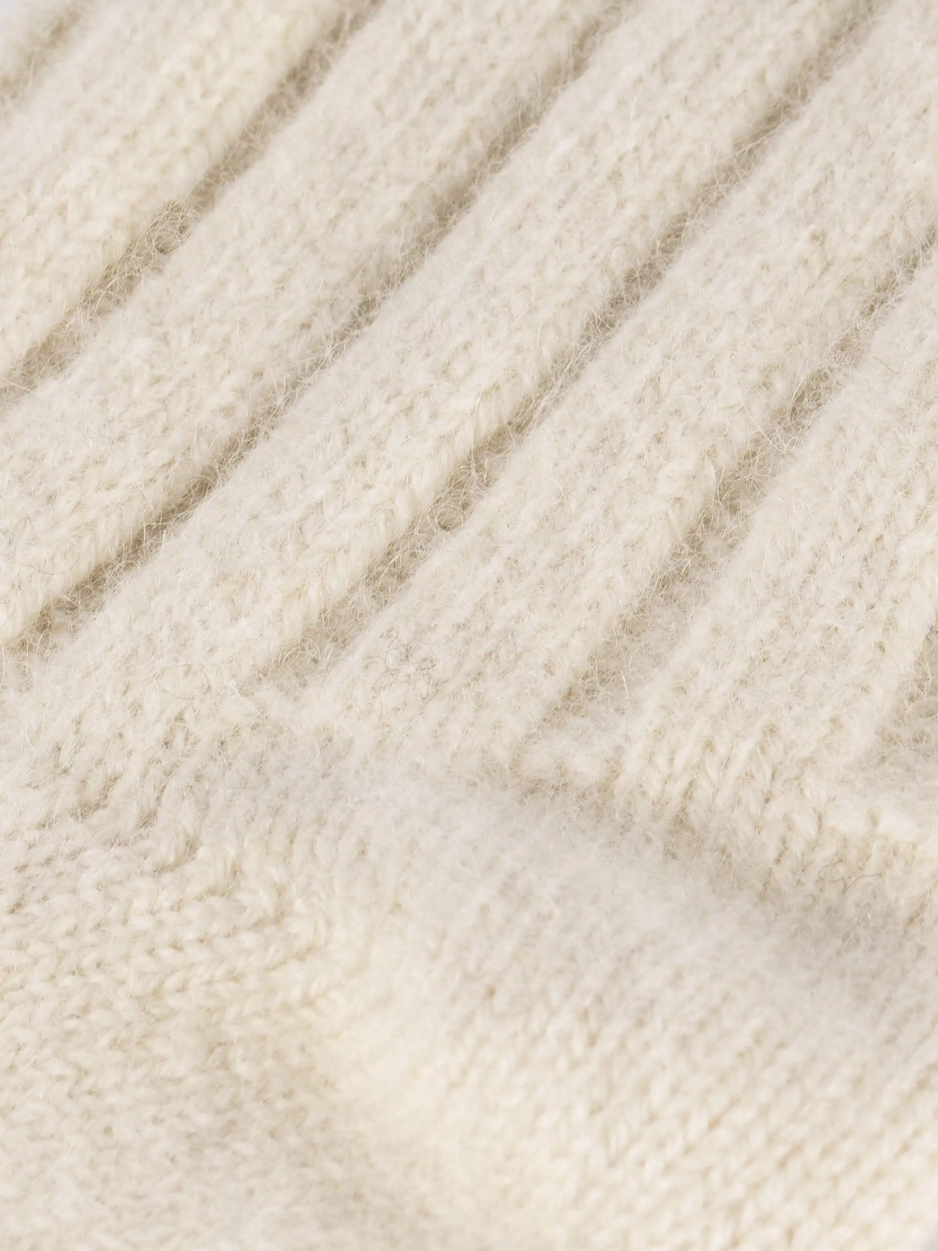 Gros plan sur la matière en cachemire beige des chaussettes, montrant la texture en laine.