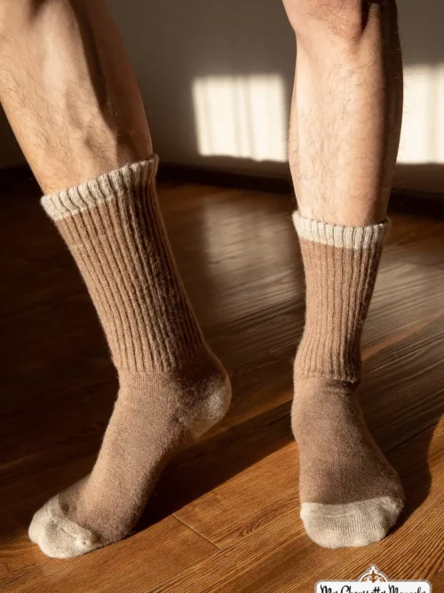 Homme en short portant des chaussettes hautes marron clair sur un sol en bois