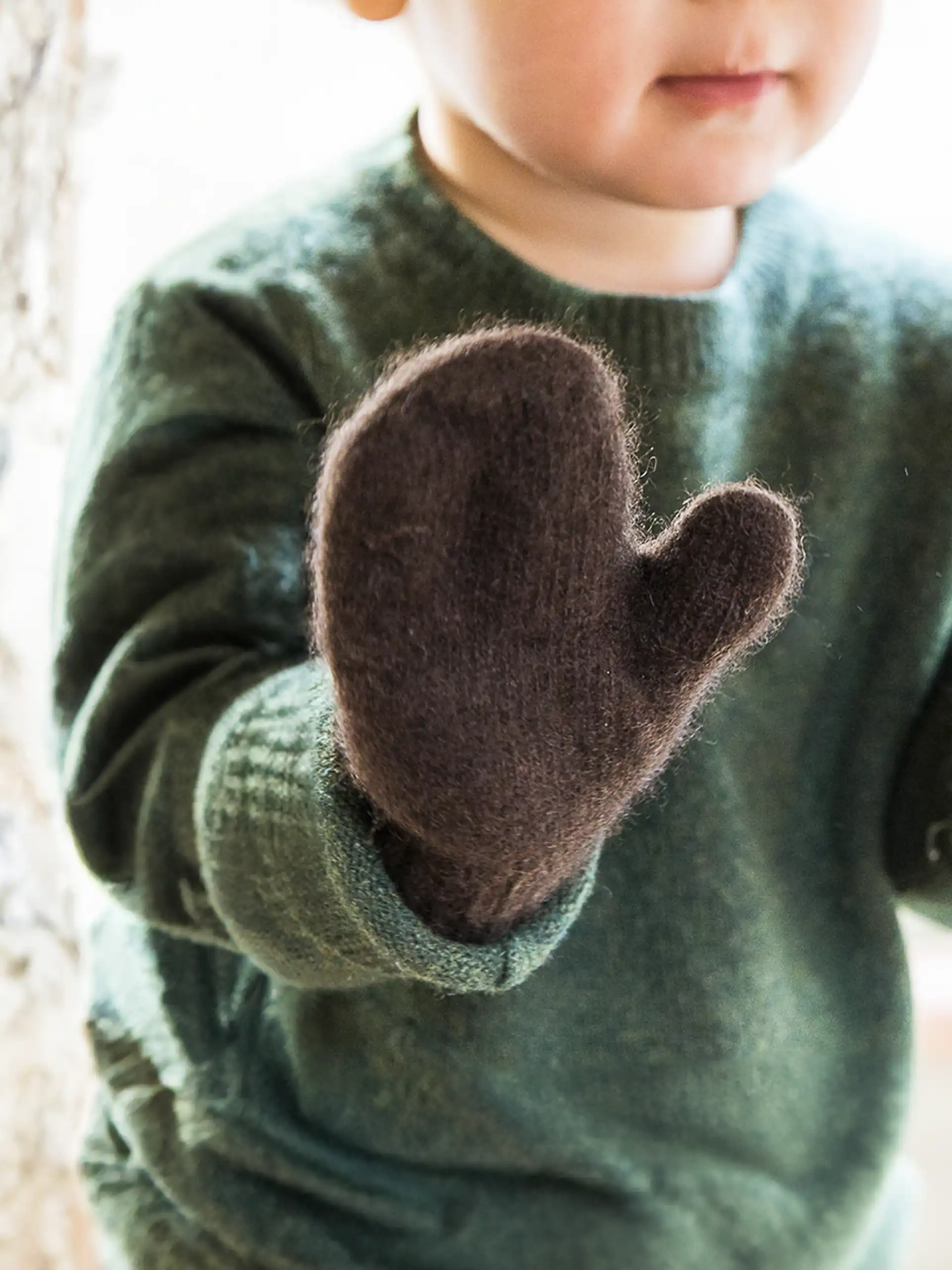 Gros plan sur des moufles enfant en maille de laine, parfaites pour le froid