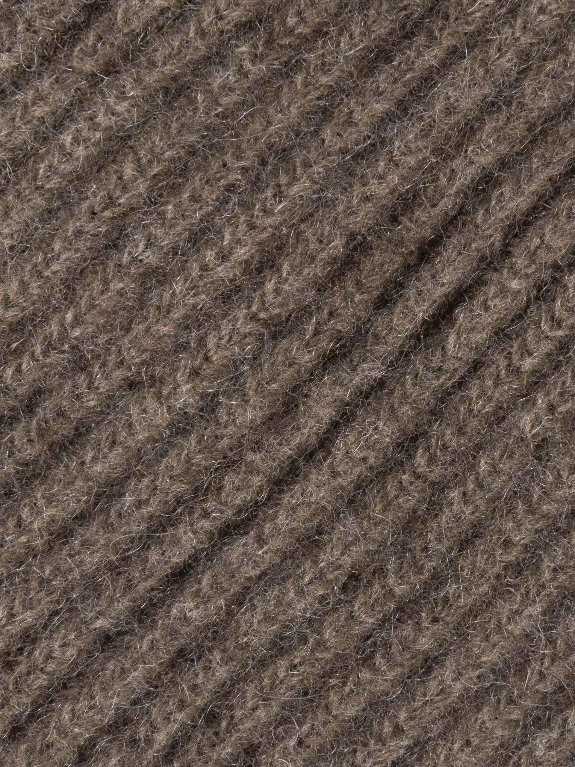 Gros plan sur la texture du tour de cou marron en maille fine de Mongolie, doux et chaud pour l'hiver.