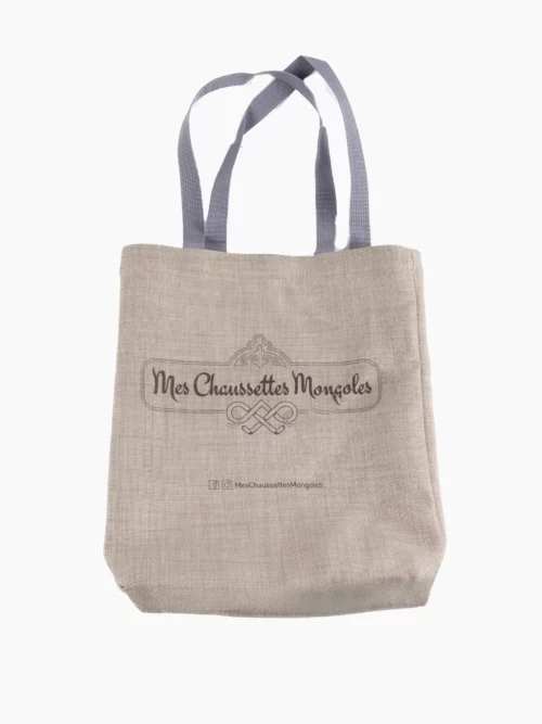 Sac en toile de couleur beige avec logo et texte “Mes Chaussettes Mongoles” imprimé au centre.