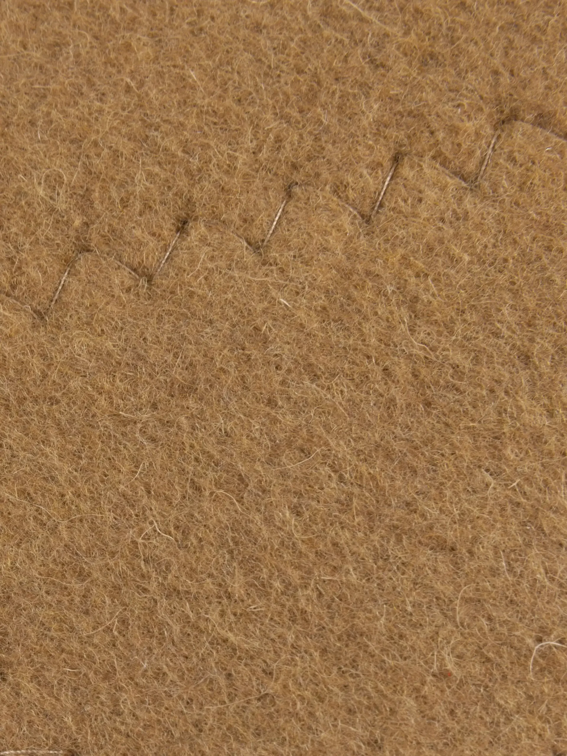 Gros plan sur la texture des semelles en feutre de duvet de chameau pour une isolation thermique optimale.