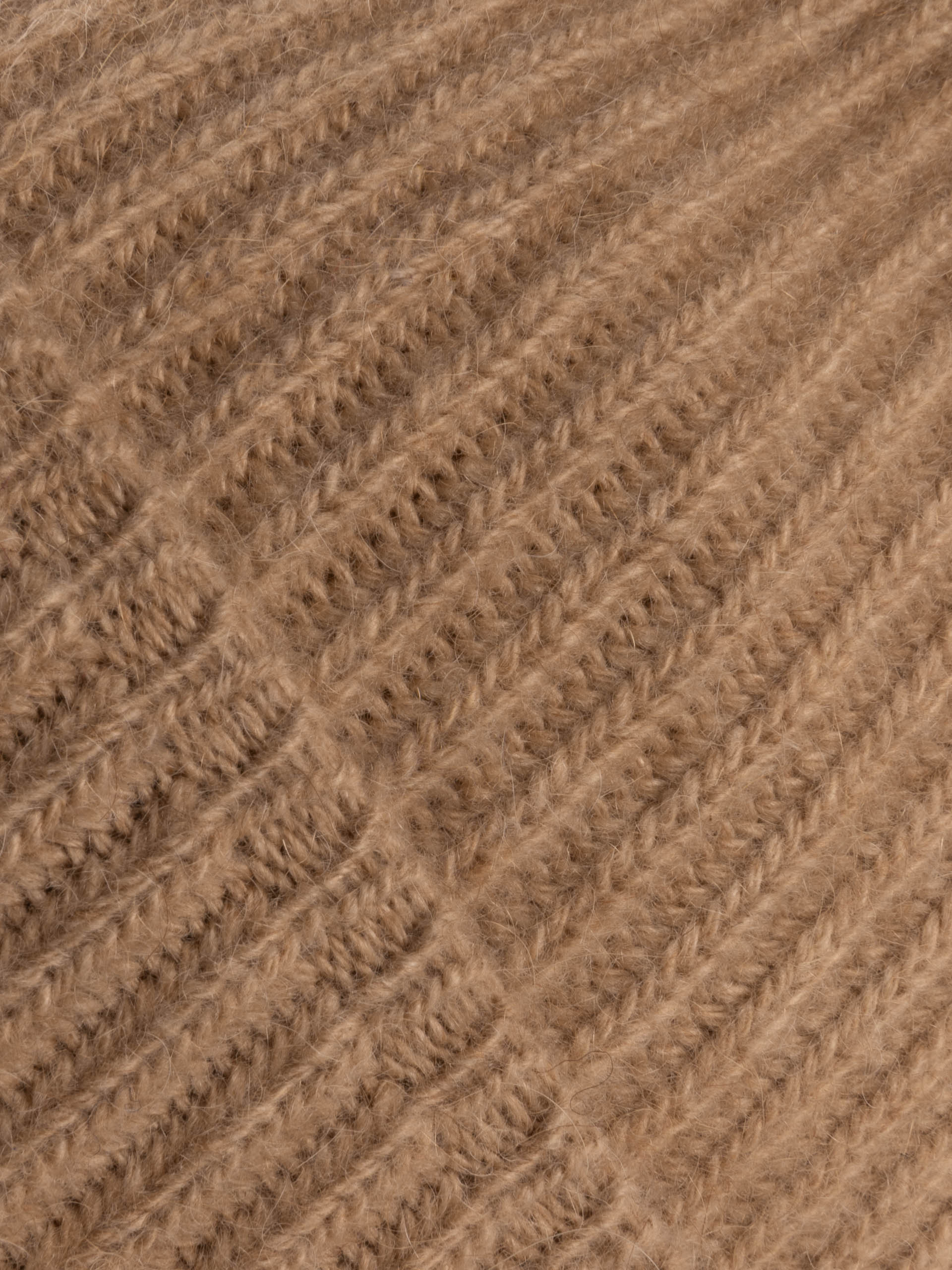 Détail de la texture tricotée d'un bonnet camel en laine douce